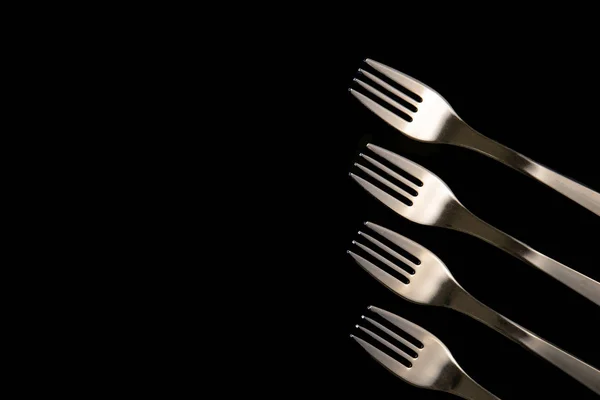 Metal forks on a black background. top view on stainless forks w — Stock Photo, Image