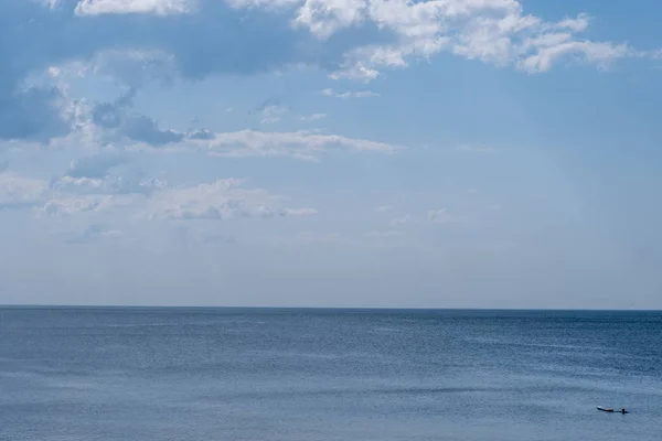 Прозоре блакитне море з красивим небом з білими хмарами — стокове фото