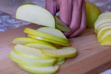 Bir t üzerinde bir kesme tahtasında dilimleri için bıçak bir elma tarafından kadın keser