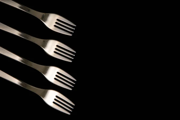 Metal forks on a black background. top view on stainless forks w — Stock Photo, Image