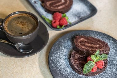 Bir pl üzerinde ahududu ile süslenmiş reçel ile çikolata İsviçre rulo