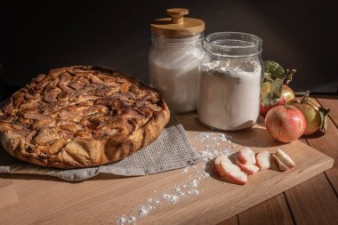 ahşap bir masada ev yapımı elma pasta, şeker ve taze elma 