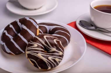 Çikolata ve kahve fincan ı ile sırlı üç Donuts.