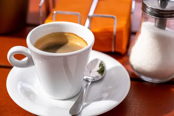 Cup of coffee and sugar bowl on a wooden table in a cafe. — Stock Photo, Image