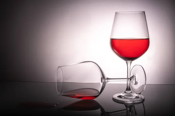 Dwa czerwone kieliszki do wina na białym tle, jedna szklana połowa pełna — Zdjęcie stockowe