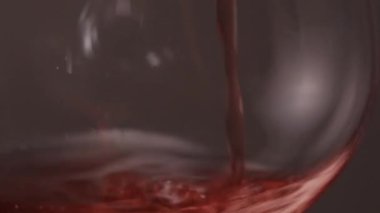 Kırmızı şarap bir bardak dökme yakın çekim.