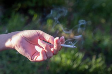 yanan bir sigara ile kadın el