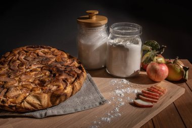 ahşap bir masada ev yapımı elma pasta, şeker ve taze elma 