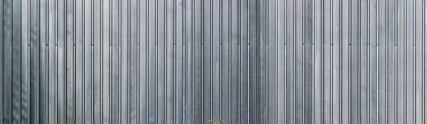 panoramic view of profiled sheet metal wall. Gray metal texture surface. Seamless background.