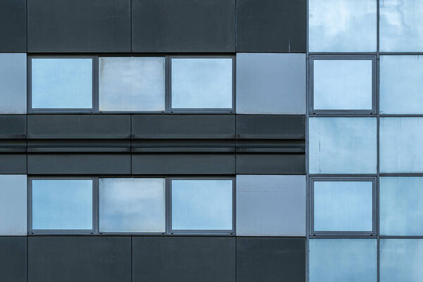 Abstract fragment of the facade of a modern building. Office building facade with windows in steel structure.