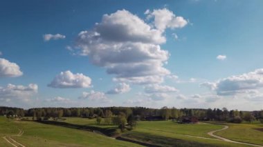 Parlak güneşli bir günde, tarlanın ve ormanın üzerinde güzel bulutlar, hareket süresi doluyor..