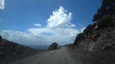 POV dolambaçlı dağ yolu bulutlu bir günde, nefes kesen uçurum ve dağlar, seyrek bitki örtüsü.