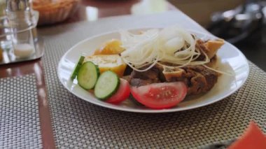 Kuzu kebabı, taze sebzeli ve kızarmış patatesli..