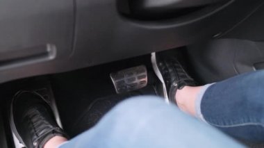 Kadın ayağı modern bir arabanın gaz pedalına basıyor. Arabayı kız kullanıyor..