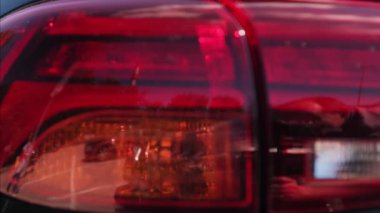 araba vücut detayı. Çağdaş bir arabanın stop lambasına yakın çekimde yanıp sönen bir dönüş sinyali..