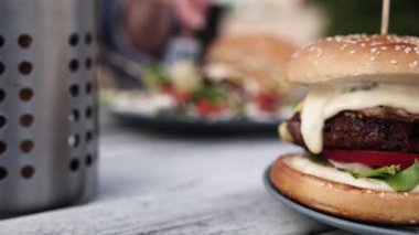 Kafedeki masada taze sebzeli sulu sığır etli burger. Etli hamburger..