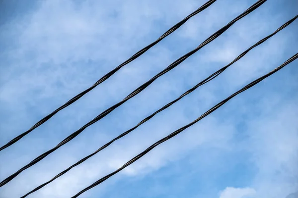 Quatro Fios Elétricos Pretos Contra Céu Azul Contexto Abstrato — Fotografia de Stock