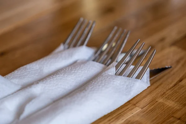 餐桌上的刀叉裹在餐巾里 放在木制桌子上 餐具套装 — 图库照片
