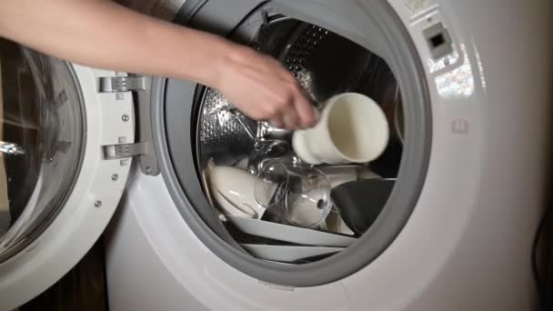 女性は汚れた食器を洗濯機に積み込む 食器洗い機がない — ストック動画
