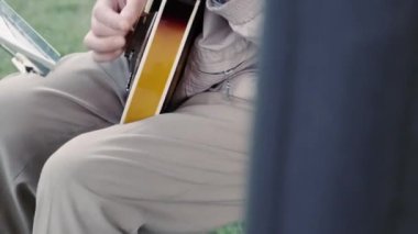 Balalayka çalan yaşlı bir adamın elleri. Sokak müzisyeni parkta gitar çalar.