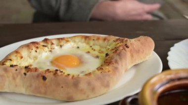Adjarian Khachapuri bir Gürcü restoranında ahşap bir masada. Bir kafede yemek..