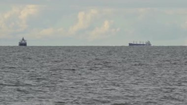 Güzel mavi deniz, küçük dalgalar ve ufukta iki yelkenli gemi..