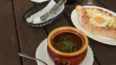 Geleneksel Gürcü Adjarian Khachapuri ve masada kızarmış bir tencere. Ev yapımı pişirme. Yukarıdan görüntüle.