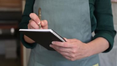 Lokantada not defteri olan kadın garson siparişi alır.,.