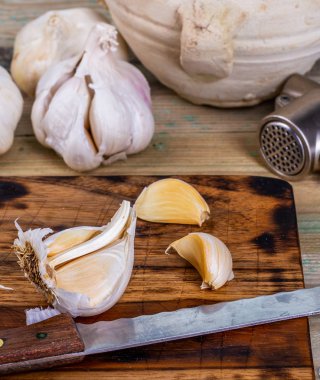 Tahta üzerinde mutfakta sarımsak ve sarımsak basın.