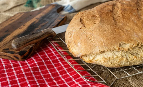 Homemade bread. Homemade pastries. Made from wheat flour. Tasty and healthy. Fresh bread on the kitchen table. For vegetarians. A loaf on the table. Slice of bread. On a chopping board.