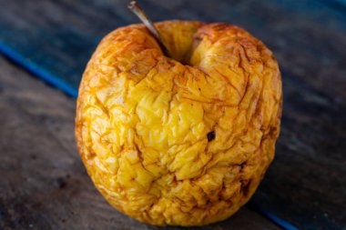 Eski elma. Kurumuş deri. Çürük meyve. Yemek israfı. Elma tahtada. Yumuşak meyve.