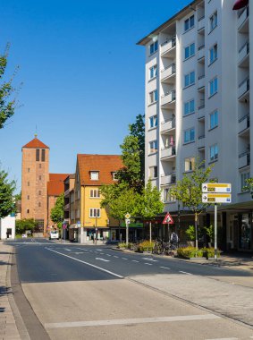 Hanau Caddesi, Hesse. Alman şehri. Sokağın sonundaki kilise kulesinde. Kırmızı tuğla duvar. Şehirde yaz. Gökyüzü açık.