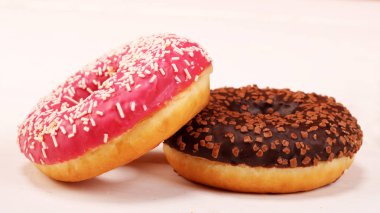 Bir somun kırıntı ve yalanla pembe krema ve Hindistan cevizi bonibon donuts ile taze çikolatalı çörek