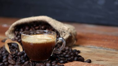 Kahve fincanı kahve çekirdekleri, çuvala ve tarçın ile