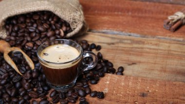 Kahve fincanı kahve çekirdekleri, çuvala ve tarçın ile