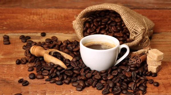 Coffee cup with Coffee beans, burlap sack and with cinnamon sticks — Stock Photo, Image