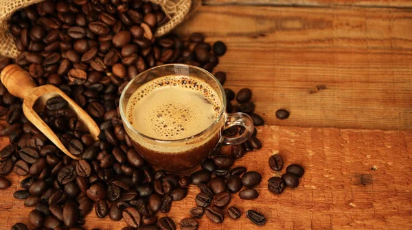 Taza de café con granos de café, saco de arpillera y con palitos de canela —  Fotos de Stock