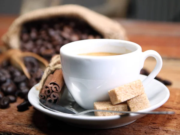 Kaffeetasse mit Kaffeebohnen, Klettenbeutel und Zimtstangen — Stockfoto