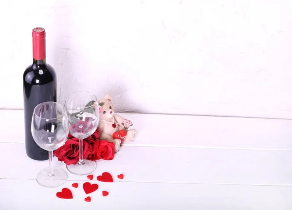 Feliz día de San Valentín con vino tinto, rosas rojas, copas de vino y corazones enamorados —  Fotos de Stock