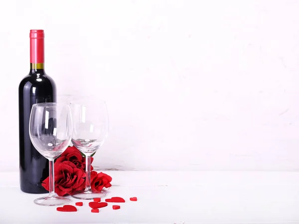 Feliz Dia dos Namorados com vinho tinto, rosas vermelhas, copos de vinho e corações apaixonados — Fotografia de Stock