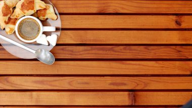 Kruvasan ve kahve bir plaka üzerinde beyaz bir fincan