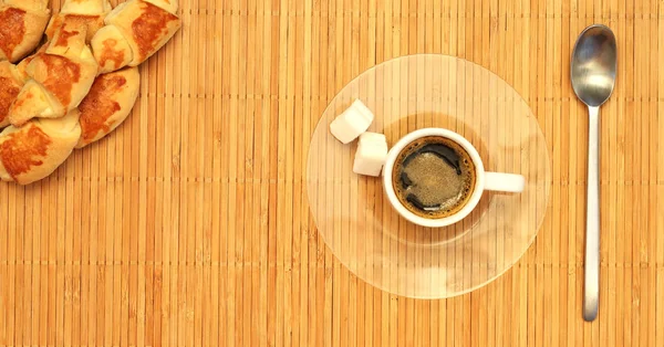 Rogalik i biały filiżankę kawy na talerzu — Zdjęcie stockowe