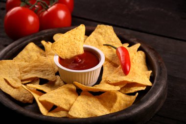 Ahşap kase tortilla cips siyah ahşap zemin üzerine biber biber sosu, salsa ve peynir dip ile Meksika cips