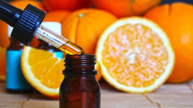 Portakal parçaları ile ahşap arka plan üzerinde portakallar uçucu yağ şişe-alternatif tıp. Portakallar ile esansiyel Aroma Yağı.