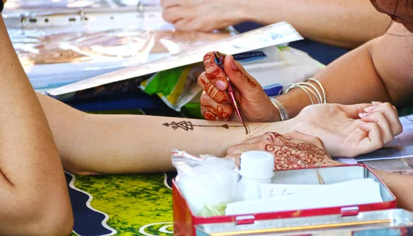 Delhi, Indien - Verfahren der Anwendung von mehndi auf weibliche Hand, aus nächster Nähe. mehndi-künstlerin malt henna auf die hand. — Stockfoto