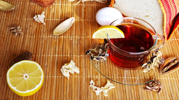 Breakfast black tea with lemon and simple food with decoration: bread, orange, egg. — Stock Photo, Image