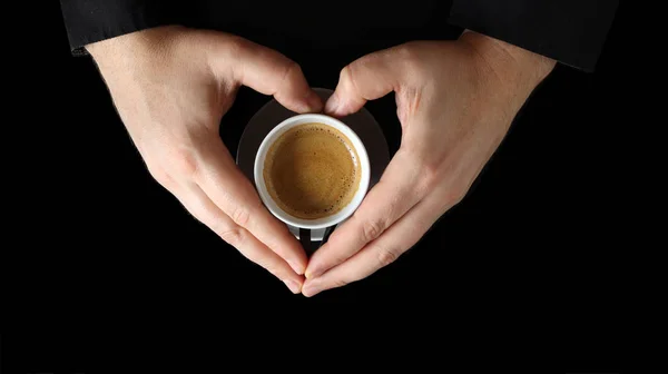 Male hand holding a coffee cup. Close up of a hand of man holding a warm mug with fresh coffee isolated on black background. Coffee concept — Stock Photo, Image