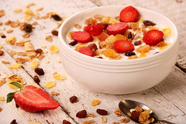 Skål med yoghurt med jordgubbar och müsli muesli, över en vit trä bakgrund. — Stockfoto