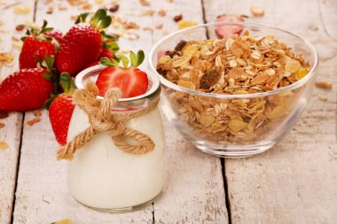 Lezzetli yoğurt ve çilek ve granola müsli ile kavanoz, ahşap masada beyaz üzerinde