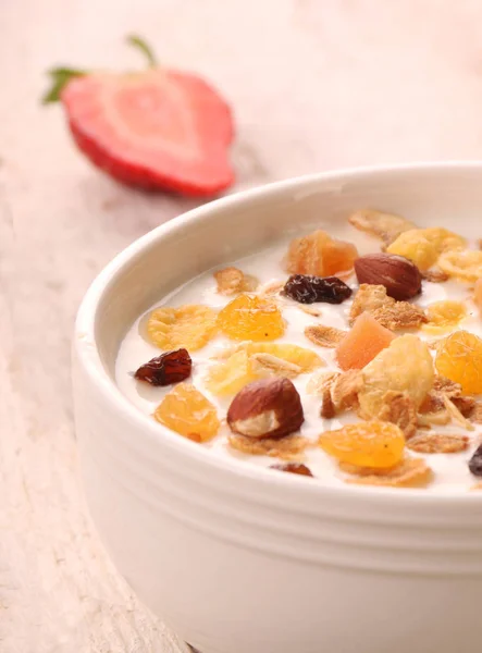 Bowl of yogurt with strawberries and granola muesli, over a white wood background. — Stock Photo, Image